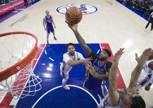 DeMarcus Cousins #15 of the Sacramento Kings attempts a shot against Jahlil Okafor #8 and Dario Saric #9 of the Philadelphia 76ers in the first quarter at the Wells Fargo Center on January 30, 2017 in Philadelphia, Pennsylvania.