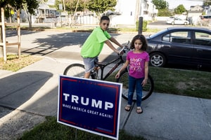 Abubeckr Elcharfa, 13, and his sister Maaria, 7, look at a neighbor's Donald Trump yard sign near their home on Staten Island in New York, Oct. 4, 2016. On the bus after school, a classmate once said to Abubeckr,