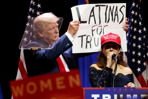 A woman joins Republican presidential nominee Donald Trump as he holds up a ''Latinas for Trump'' sign during a campaign rally at the Venetian Hotel in Las Vegas, Nevada, U.S. October 30, 2016.