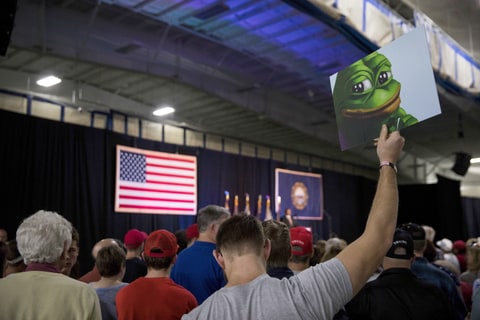 An attendee holds up a sign of Pepe the Frog, a cartoon tied to anti-Semitism and racism that has become an unofficial mascot of the alt-right, during a campaign event with Donald Trump at a sports complex in Bedford, N.H., Sept. 29, 2016. Secret Service agents later confiscated the sign.