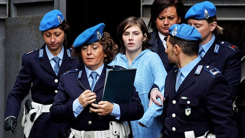PERUGIA, ITALY - NOVEMBER 24: Amanda Knox (C) is led away from Perugia's Court of Appeal by police officers after the first session of her appeal against her murder conviction on November 24, 2010 in Perugia, Italy. American Amanda Knox and her Italian ex-boyfriend Raffaele Sollecito were convicted of the murder of Ms Knox's former British flatmate Meredith Kercher in 2007. Their initial trial completed in December 2009 with Knox and Sollecito receiving sentences of 26 and 25 years respectively. Rudy Guede, an unemployed man from Ivory Coast, was also convicted of the murder of Meredith Kercher. The case is also forming the basis for a film currently being shot in Italy entitled 'The Amanda Knox Story', with American actress Hayden Panettiere cast as Amanda Knox. (Photo by Oli Scarff/Getty Images)