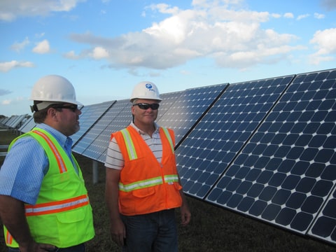 Florida Power & Light employees Jose Suarez, left, and Greg Bove, stand beside solar panels Wendesday, Oct. 21, 2009 at the DeSoto Next Generation Solar Energy Center in Arcadia, Fla., which will be the largest solar photovoltaic plant in the country.