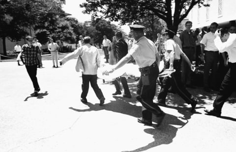 In this Aug. 1, 1966, file photo, one of the victims of Charles Whitman, the sniper who gunned down victims from a perch in the University of Texas tower, is carried across the campus to a waiting ambulance in Austin. The unidentified victim was gunned down inside the tower, according to police on the scene.