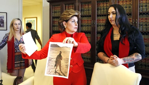 Active-duty Marine Marisa Woytek, left, joins former Marine Erika Butner, right, and attorney Gloria Allred holding photos of Butner in uniform, as the women said photographs of them were secretly posted online without their consent, at a news conference in Los Angeles Wednesday, March 8, 2017. Nude photos of other servicewomen were also posted. Gen. Robert Neller, the Marine Corps commandant, has condemned the photo sharing and urged victims to report abuse.