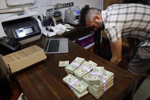 In this June 27, 2017, photo, bundles of $20 bills are placed on a table as Jerred Kiloh, owner of the Higher Path medical marijuana dispensary, prepares a trip to Los Angeles City Hall to pay his monthly tax payment in cash in Los Angeles. For Kiloh, the cash is a daily hassle. It needs to be counted repeatedly to safeguard against loss. State and local taxes must be set aside and stored, sometimes for a month or more. When vendors show up, they get paid in cash, too.