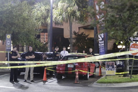 Officers are processing possible evidence and a red sports car at a McDonalds in Ybor City in Tampa, Fla, Tuesday, Nov. 28, 2017. Tampa Police Chief Brian Dugan says Howell Emanuel Donaldson, 24, will be charged with four counts of first degree murder in connection with deaths in the Seminole Heights neighborhood. Police detained the man earlier Tuesday after a tip that he had a gun at a McDonald's.