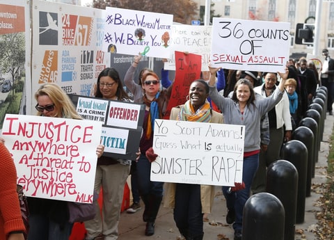 Protestors carry signs outside the courthouse as the jury deliberates in the trial of Daniel Holtzclaw, in Oklahoma City, Tuesday, Dec. 8, 2015. Holtzclaw is a former police officer accused of sexually victimizing 13 women in the neighborhood he patrolled.