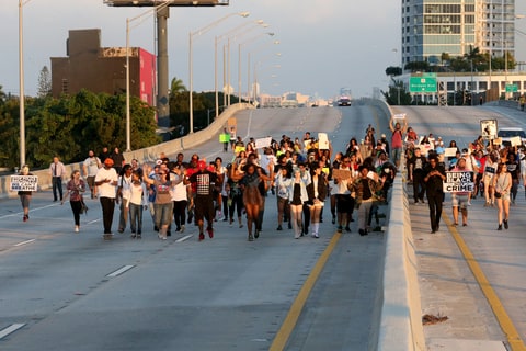 Demonstrators march along Interstate 195 after police shut the road down as they protest police abuse on December 7, 2014 in Miami, Florida. The protest was one of many that have take place nationwide after grand juries investigating the deaths of Michal Brown in Ferguson, Missouri and Eric Garner in New York failed to indict the police officers involved in both incidents