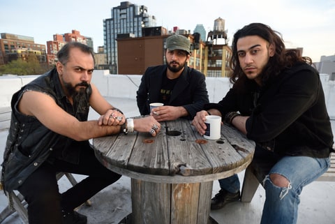 Members of the Iraqi heavy metal band Acrassicauda, (L to R) singer Faisal Mustafa, drummer and lyricist Marwan Hussein and guitarist Moe Al Hamawandi, pose for a photo on the roof of Spin Recording Studios April 30, 2015 in New York. The three Iraqi musicians have found a form of therapy not by firing guns but by banging their heads to heavy metal