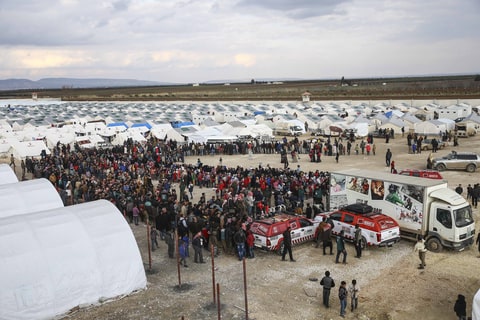 Syrians, who fled bombing in Aleppo, wait in a queue to get food at a tent city and close to the Bab al-Salam border crossing on Turkish-Syrian border near Azaz town of Aleppo, Syria on February 10, 2016. Russian airstrikes have recently forced some 40,000 people to flee their homes in Syrias northern city of Aleppo.