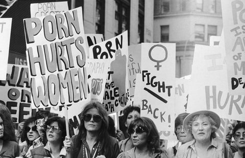 Gloria Steinem (center), one of the more celebrated figures in the feminist movement, is among the more than 5,000 participants in a march against pornography in New York. Marching through Times Square, feminists, college students and community activists paraded in the bright sunlight past dimly lighted sex shops, peep shows, and pornographic movie houses along 42nd Street