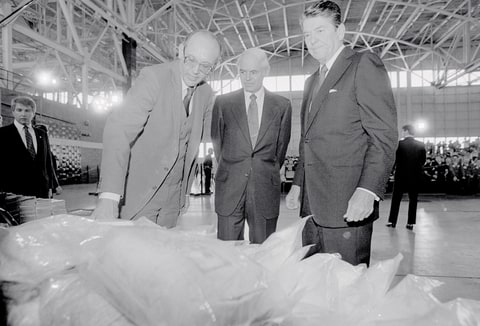 President Ronald Reagan (right) inspects a pile of confiscated cocaine 11/17 with U.S. Attorney General William F. Smith (center) and South Florida Task Force on Crime director Charles Rinkezich (left). President Reagan also viewed in the airplane hangar a stack of baled marijuana and aircraft used by government agencies to catch drug smugglers.