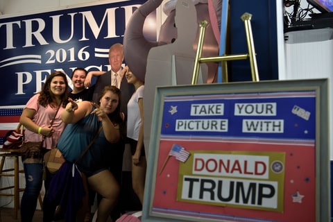 Women pose with a cardboard cutout of Donald Trump at the Shenandoah County Fair in Woodstock, Virginia.