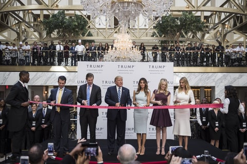 Republican presidential candidate Donald Trump, accompanied by, from left, Donald Trump Jr., Eric Trump, Trump, Tiffany Trump, Melania Trump, and Ivanka Trump, prepare to cut a ribbon during the grand opening ceremony of the Trump International Hotel- Old Post Office in Washington, DC on Wednesday October 26, 2016.