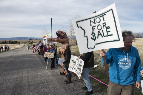 Protestors hold signs at a rally for Republican Greg Gianforte as he campaigns for the Montana House of Representatives seat vacated by the appointment of Ryan Zinke to head the Department of Interior on April 22, 2017 in Bozeman, Montana. Donald Trump Jr. appeared at the event to support Gianforte who is running against democrat Rob Quist in the special election to be held on May 25, 2017.