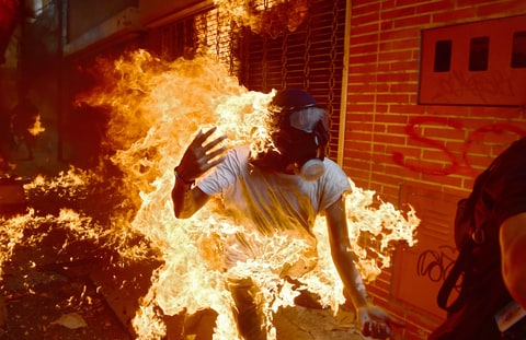 A demonstrator catches fire during clashes with riot police within a protest against Venezuelan President Nicolas Maduro, in Caracas on May 3, 2017. Venezuela's angry opposition rallied Wednesday vowing huge street protests against President Nicolas Maduro's plan to rewrite the constitution and accusing him of dodging elections to cling to power despite deadly unrest
