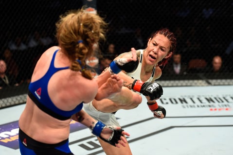 Cris Cyborg of Brazil kicks Tonya Evinger at UFC 214