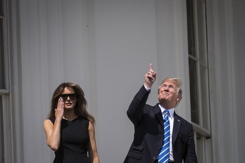President Donald Trump looks up toward the Solar Eclipse with out glasses, with first lady Melania Trump by his side, from a balcony at the White House in Washington, DC on Monday, Aug 21, 2017.