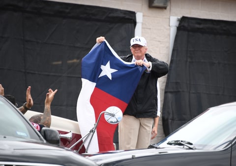 US President Donald Trump holds the state flag of Texas outside of the Annaville Fire House after attending a briefing on Hurricane Harvey in Corpus Christi, Texas on August 29, 2017. President Donald Trump flew into storm-ravaged Texas Tuesday in a show of solidarity and leadership in the face of the deadly devastation wrought by Harvey -- as the battered US Gulf Coast braces for even more torrential rain.
