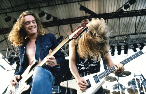 Photo of METALLICA and Cliff BURTON and James HETFIELD; Cliff Burton (playing Rickenbacker bass) and James Hetfield (playing Gibson Flying V guitar) performing live onstage