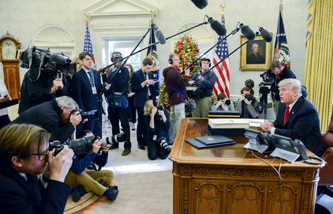 U.S. President Donald Trump speaks to members of the media after signing a tax-overhaul bill into law in the Oval Office of the White House in Washington, D.C., U.S., on Friday, Dec. 22, 2017. This week House Republicans passed the most extensive rewrite of the U.S. tax code in more than 30 years, hours after the Senate passed the legislation, handing Trump his first major legislative victory providing a permanent tax cut for corporations and shorter-term relief for individuals.