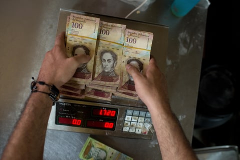 Hyperinflation, piles of 100 bolivars are weighted instead of counting due to their small value. Venezuela. A trader weighs wads of one hundred bills in a Caracas trade on October 31, 2016. Inflation, which the IMF predicts to 700% in 2016, has led traders despite the money to count it faster.