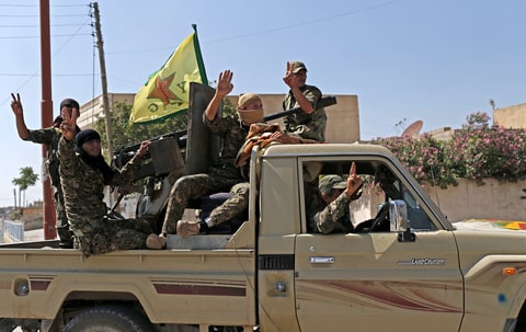 Members of Kurdish People Defence Units (YPG) flash victory sign after coming from Syrian town of al-Raqqa, in Tel Abyad, Syria, 23 June 2015. Kurdish fighters backed by US-led airstrikes captured a strategic town from Islamic State on 23 June
