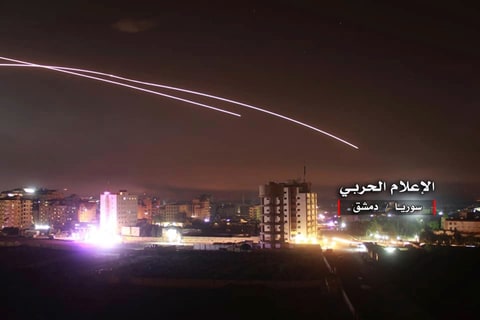 In this image, distributed on May 10, 2018 by the Syrian Government's Central Military Media, missiles can be seen flying across the sky while an Israeli projectile reaches an anti-aircraft position and other military bases in Damascus, Syria.