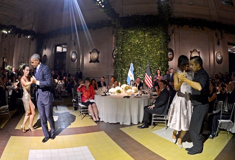 President Obama tangos with a dancer as first lady Michelle Obama tangos with another dancer nearby, during the official state dinner at the Centro Cultural Kirchner in Buenos Aires on March 23, 2016.