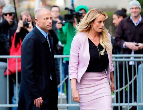 Stormy Daniels and her attorney Michael Avenatti turn from the microphones after speaking as they leave federal court in New York abotu the Trump Russia Probe in April 2018.