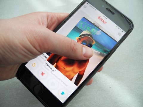 A user holds up a smartphone displaying the app Tinder in New York, USA; 29 March 2016
