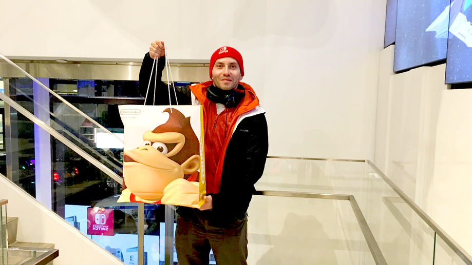 An exhausted fan shows off his midnight purchase of the Nintendo Switch – complete with 'Donkey Kong' bag