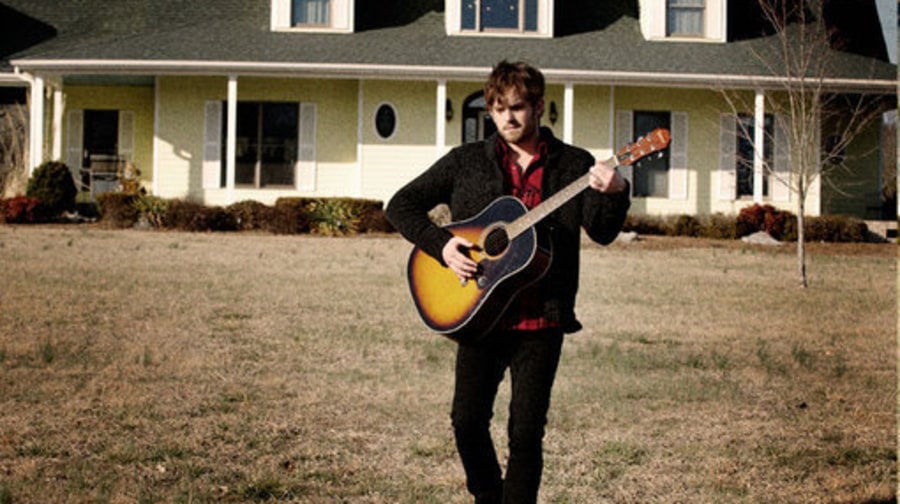 Caleb Followill Playing Guitar In Front of House